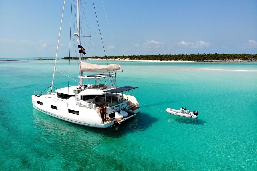 Lagoon 46 catamaran at anchor in turquoise water with tender